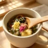 Présentation jian fan mei yan cha infusée Présentation d'ingrédients sur une cuillère de la tisane jian fan mei yan cha infusée