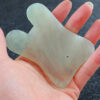 Gua Sha en jade dans main Gua sha dans main